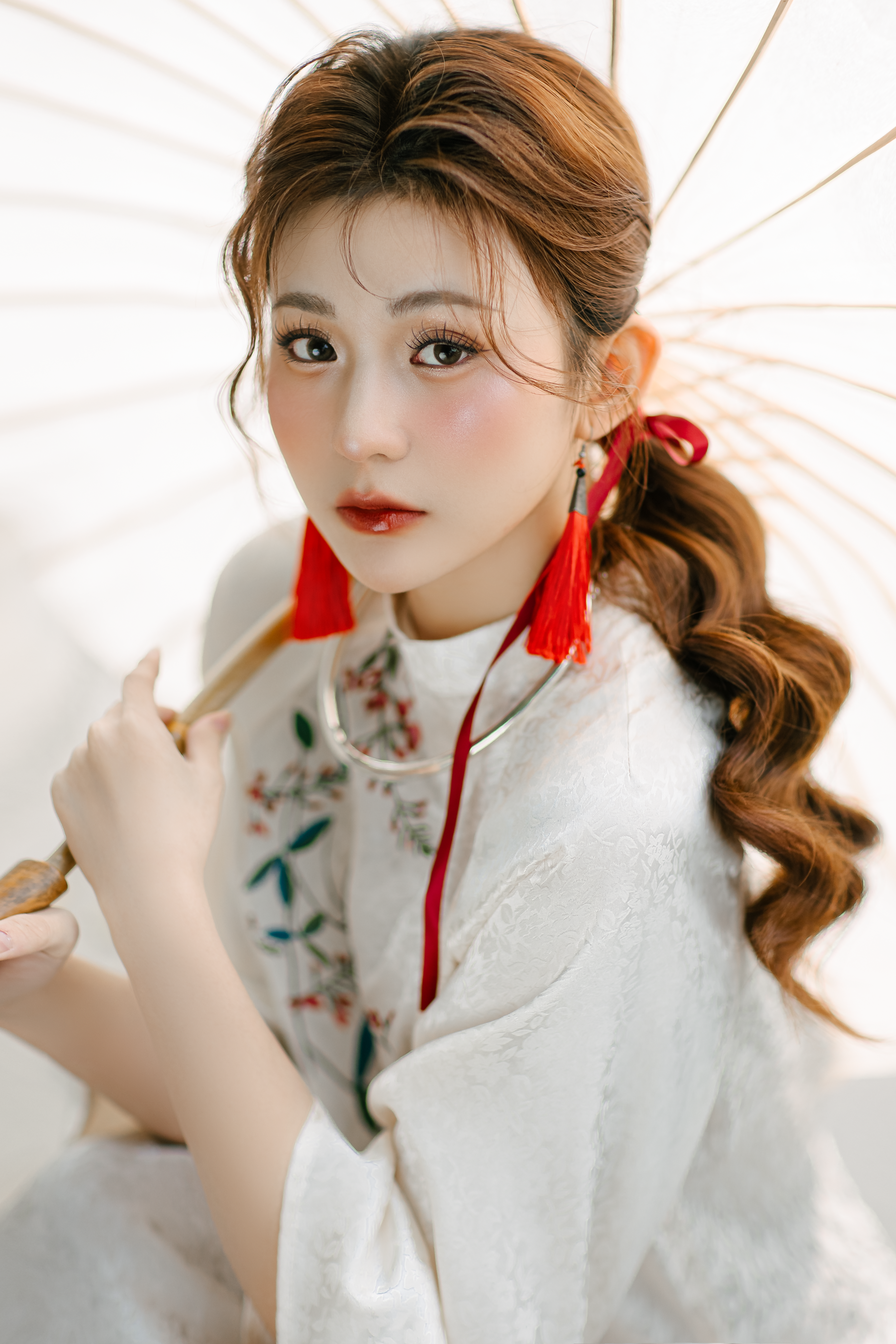 Elegant portrait of a young woman in traditional attire holding a parasol.
