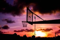 Basketball hoop silhouetted against a sunset, photo by Wallace Chuck on Pexels