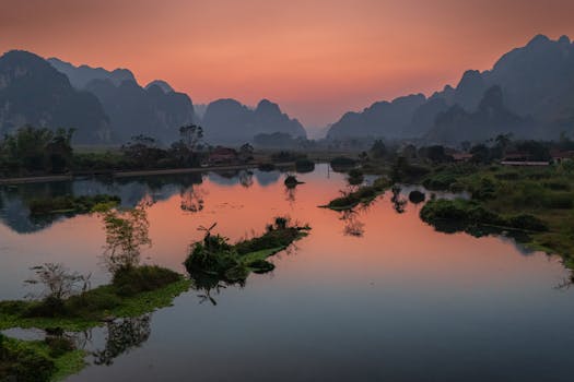 A breathtaking sunset view over the tranquil lake surrounded by mountains in Lạng Sơn, Vietnam.