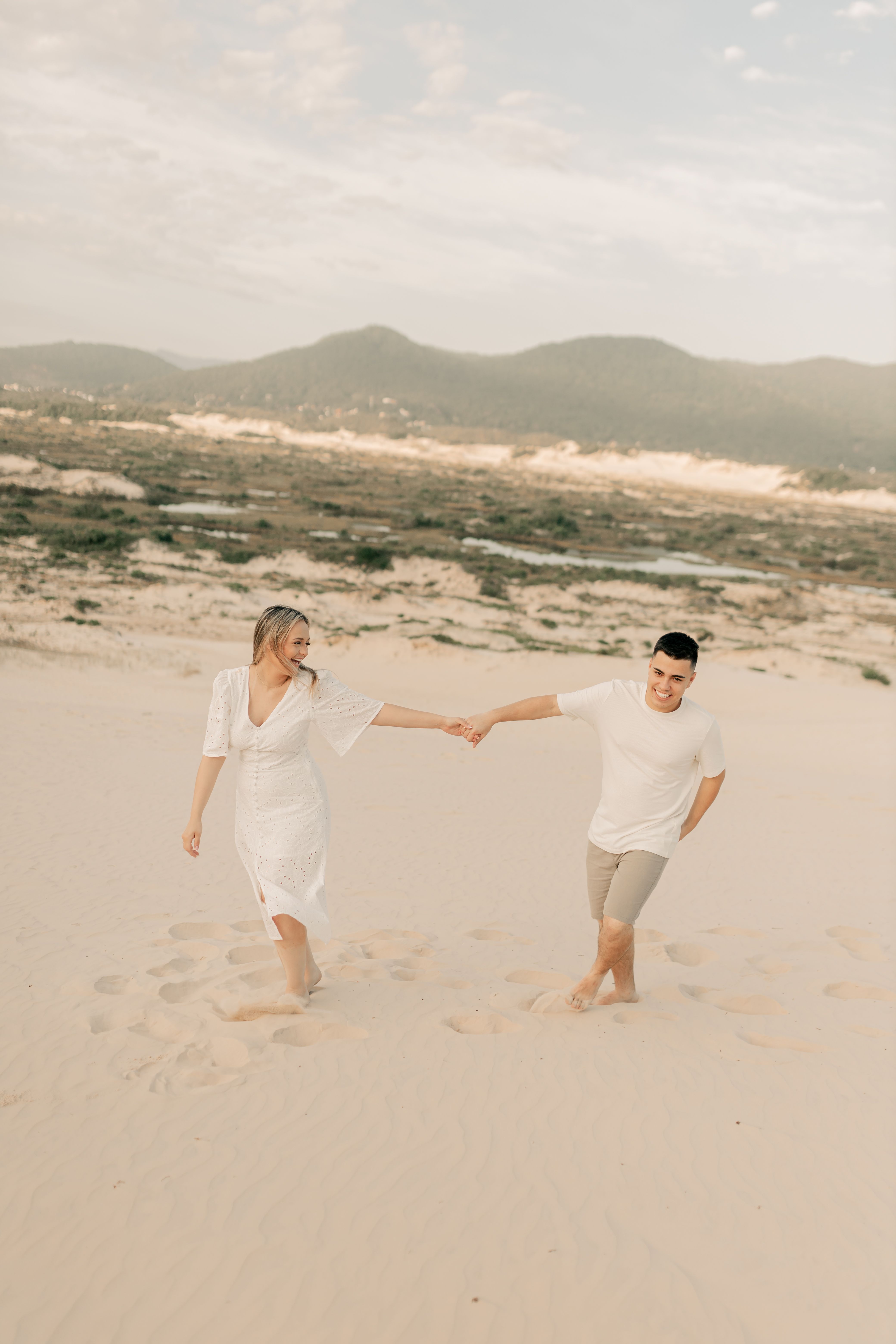 Happy couple walking hand in hand on sandy beach · Free Stock Photo