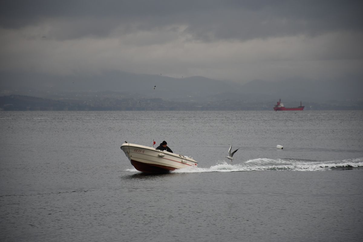 Small boat cruising on a calm, overcast sea