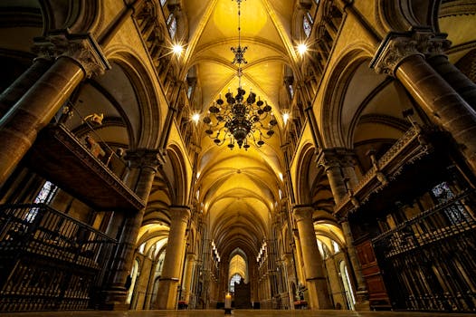 The stunning Gothic architecture of Canterbury Cathedral's interior with arched ceilings and chandeliers.