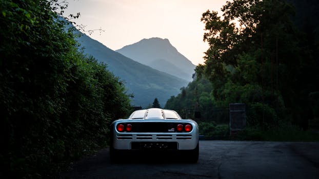 A stunning supercar parked on a scenic mountain road during twilight.