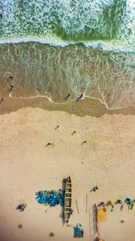 Drone shot capturing the vibrant beach scene in Accra, Ghana with people and boats.