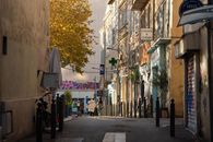 Idyllic street view with people walking in the warm glow of Marseille, capturing urban charm and local life.