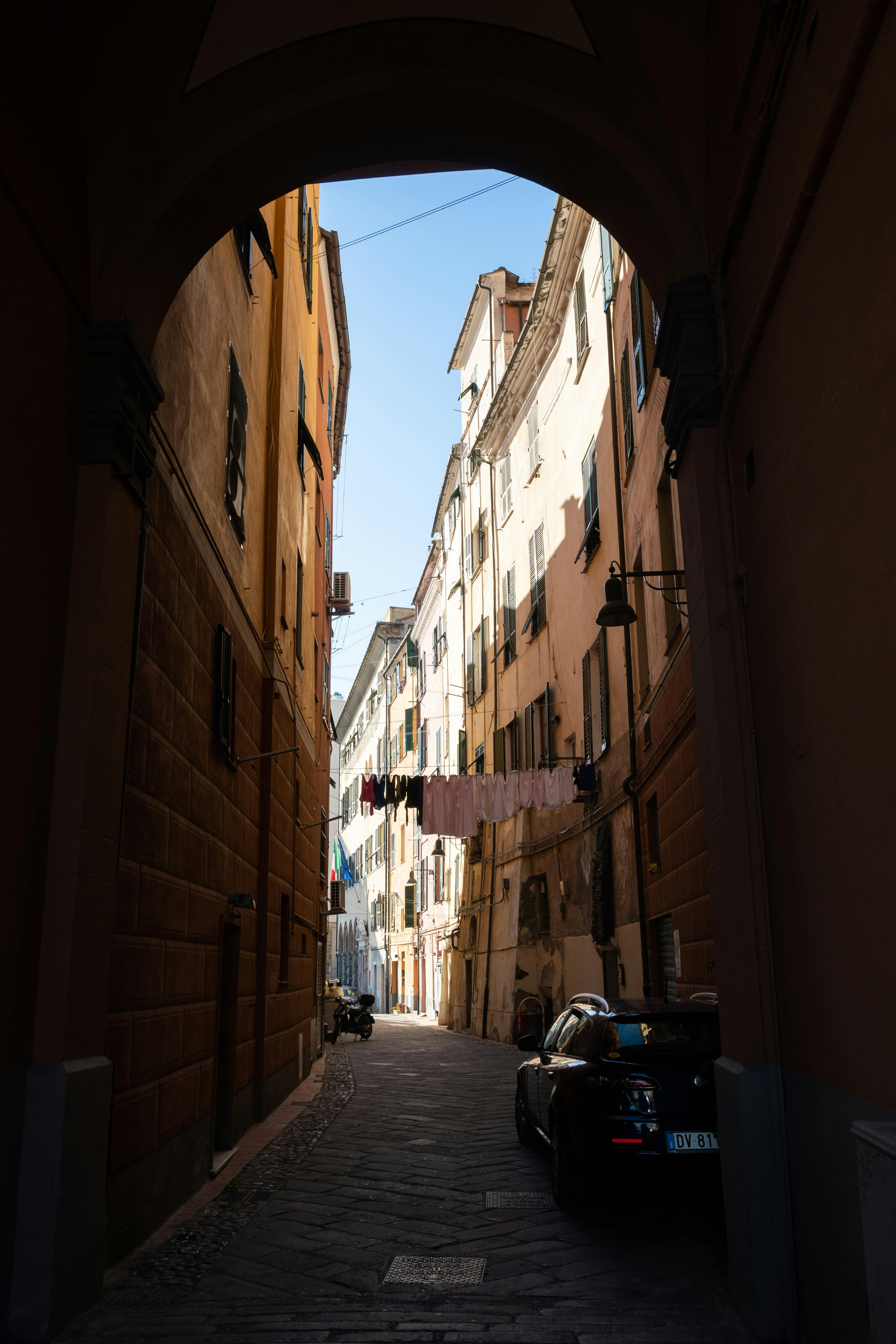 A picturesque view of a narrow alleyway in Savona, Italy, capturing historic architecture.