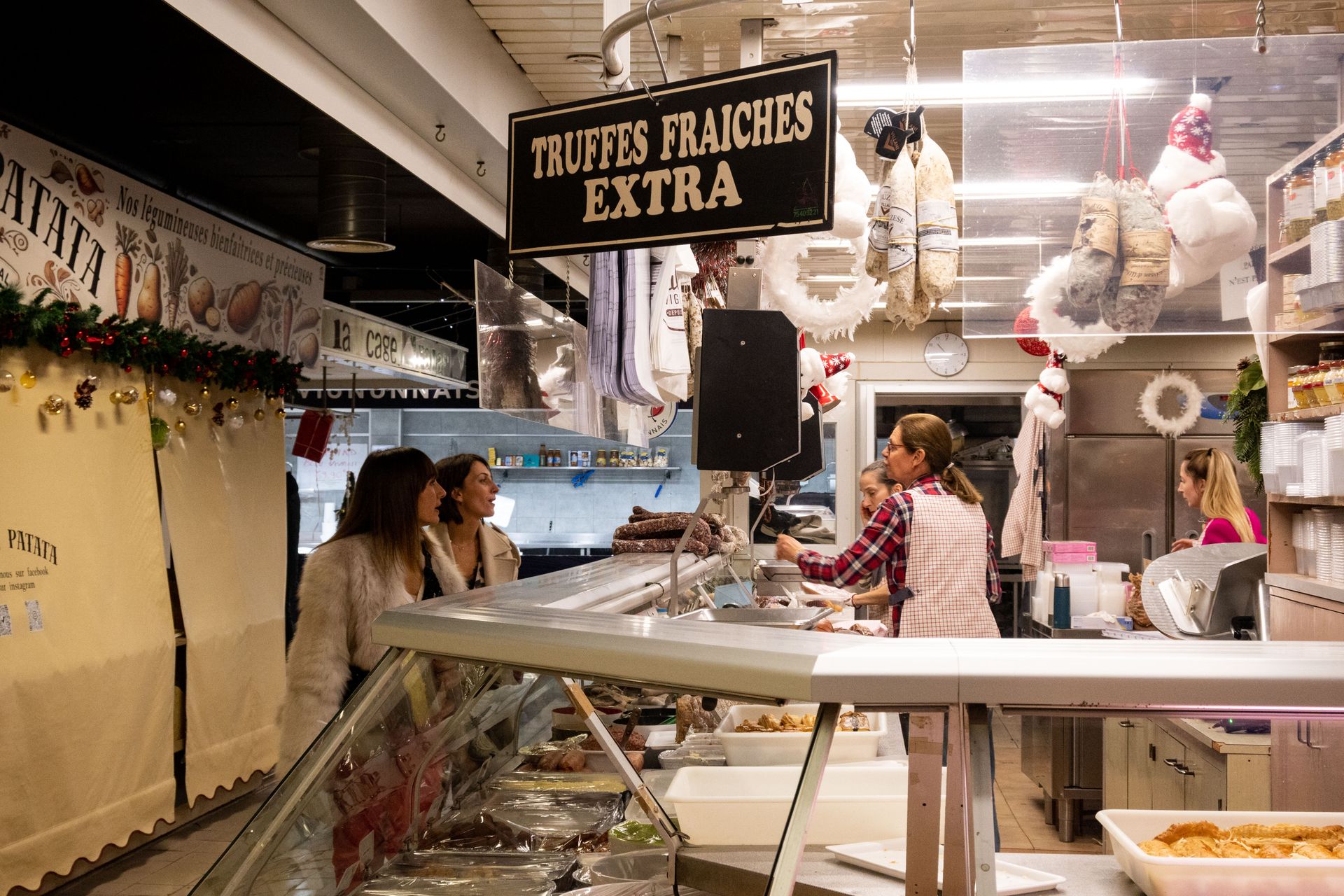 A covered market counter in Avignon under a sign reading Truffes Fraîches Extra
