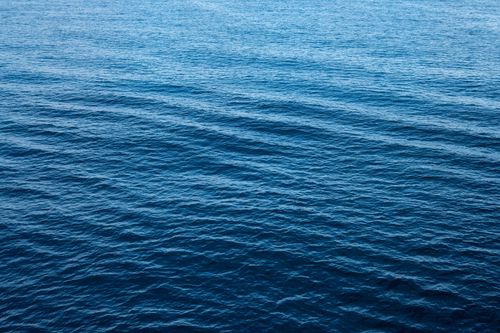 Free Peaceful view of ocean waves with a vibrant blue hue, capturing tranquility and vastness. Stock Photo
