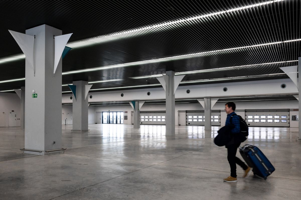 Traveller with a suitcase crossing an empty terminal
