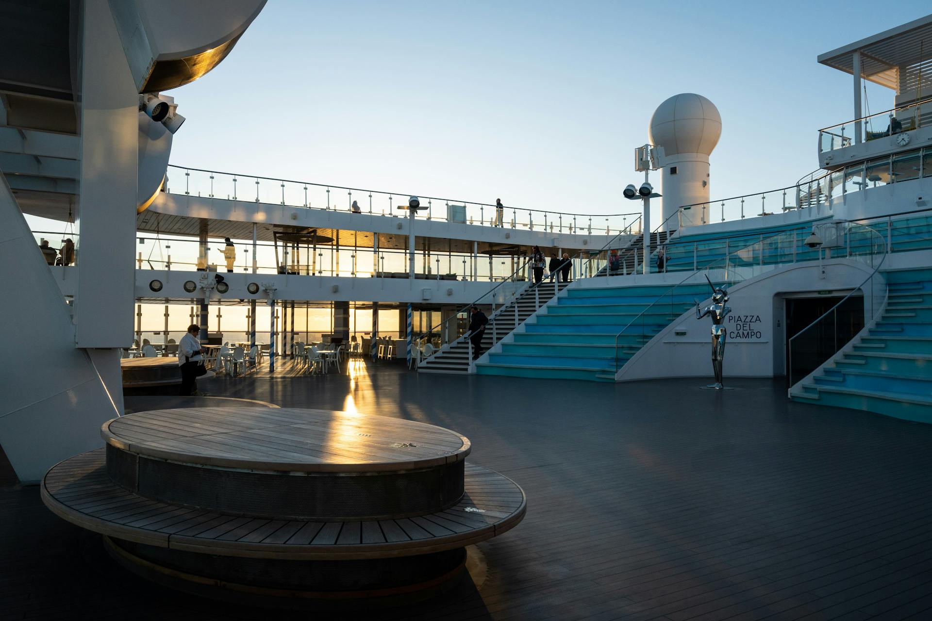 Elegant cruise ship deck at sunset with modern design and tranquil atmosphere.