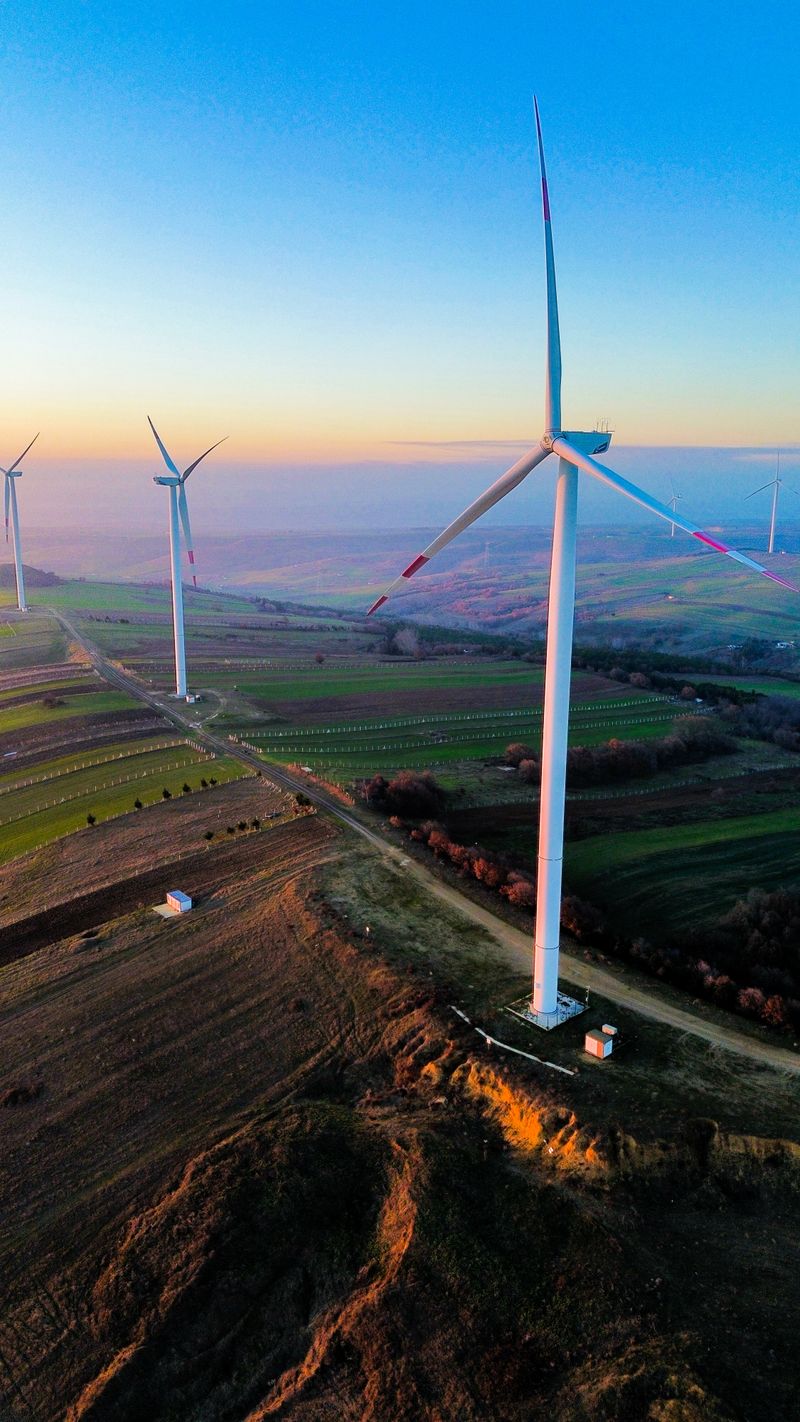 Wind farm seen from above at sunrise, the variable renewable generation that gigawatt-scale battery storage balances