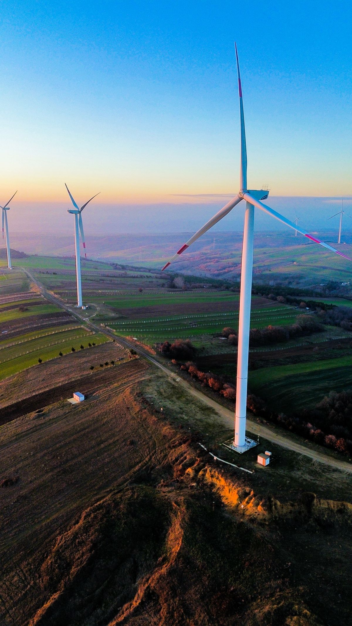 Wind Turbines at Sunset Over Rolling Hills · Free Stock Photo