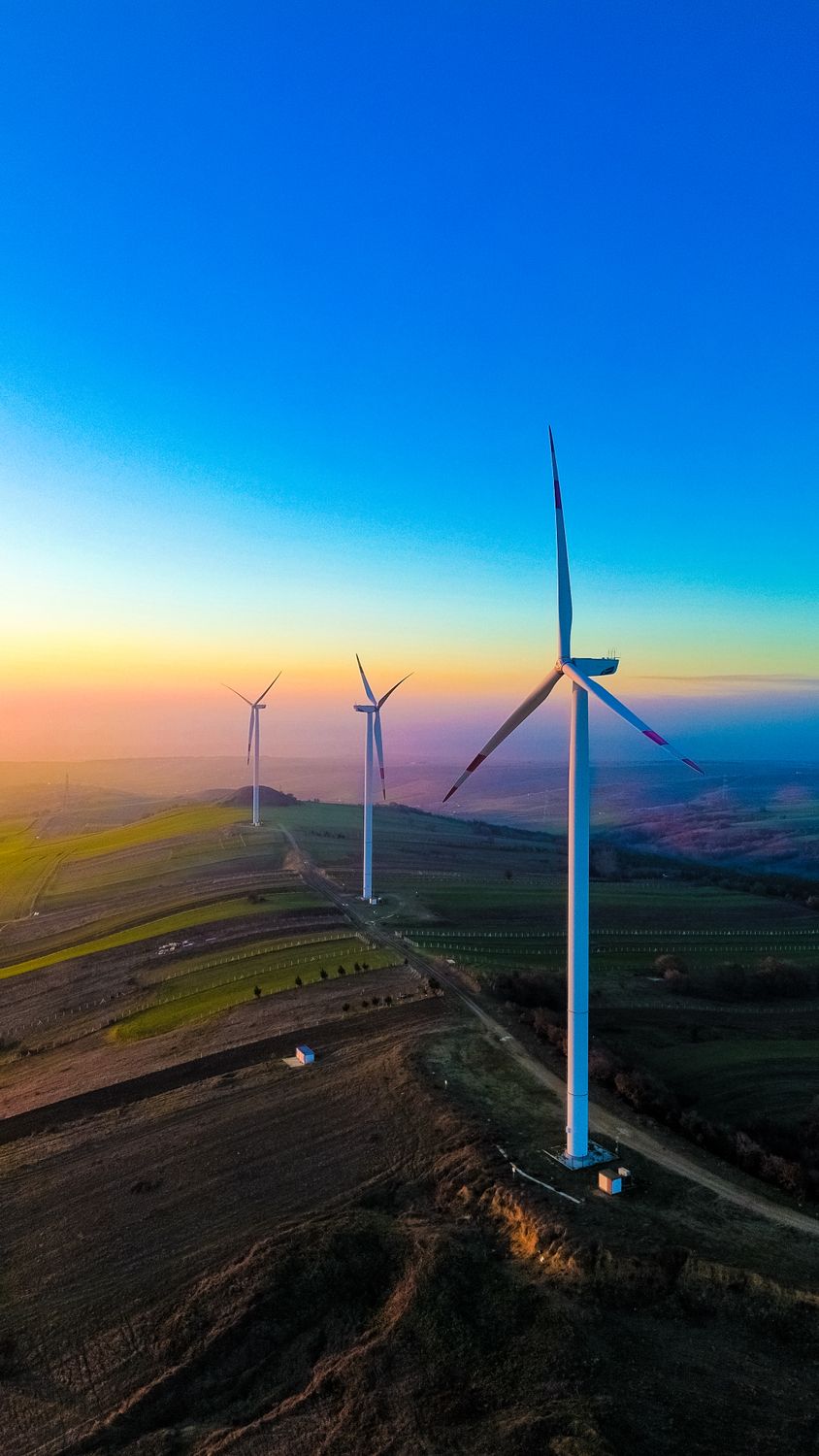 Wind Turbines at Sunset Over Rolling Hills · Free Stock Photo