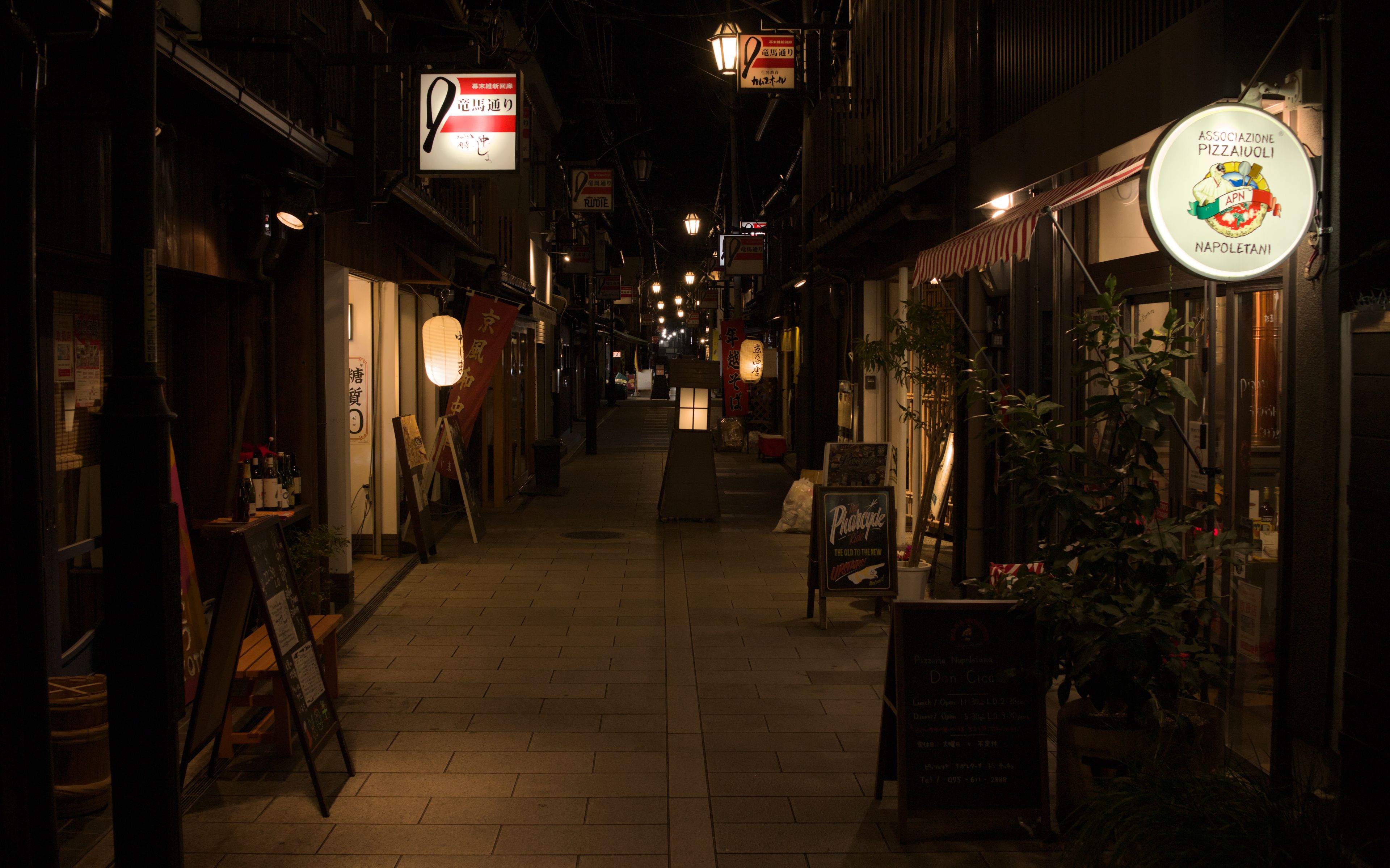 A quiet Japanese alleyway at night lined with traditional shops and warm lights, a real stock photo chosen because the Tim Burton and Kazuo Ishiguro film is reportedly set in Japan after World War II. It is not a still from the movie