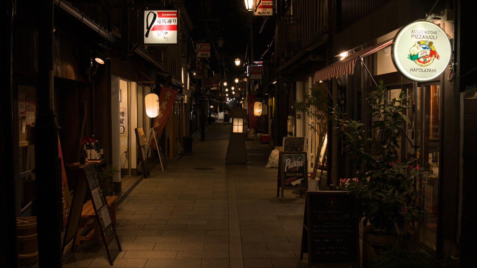 A quiet Japanese alleyway at night lined with traditional shops and warm lights, a real stock photo chosen because the Tim Burton and Kazuo Ishiguro film is reportedly set in Japan after World War II. It is not a still from the movie