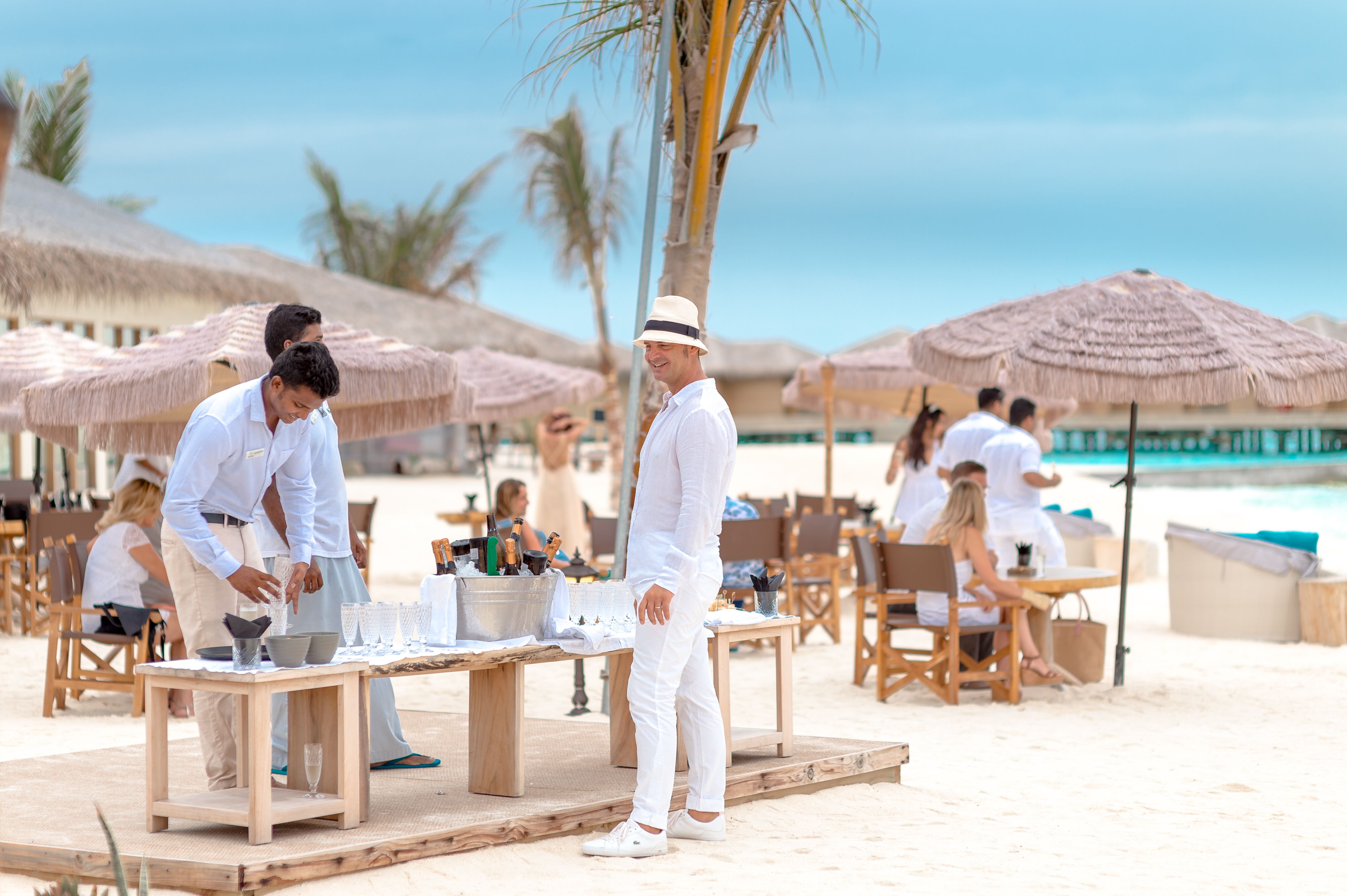 Elegant Beach Party with Guests in White Attire · Free Stock Photo