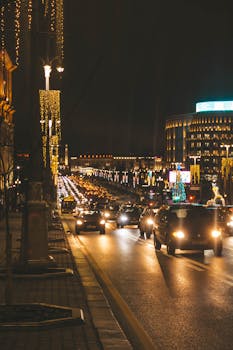 Vibrant city street at night with holiday lights and bustling traffic, creating an urban festive atmosphere.