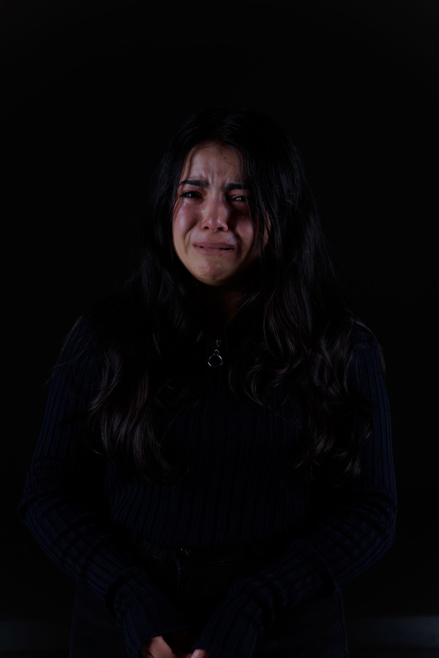 Mujer llorando de noche, con el corazón roto