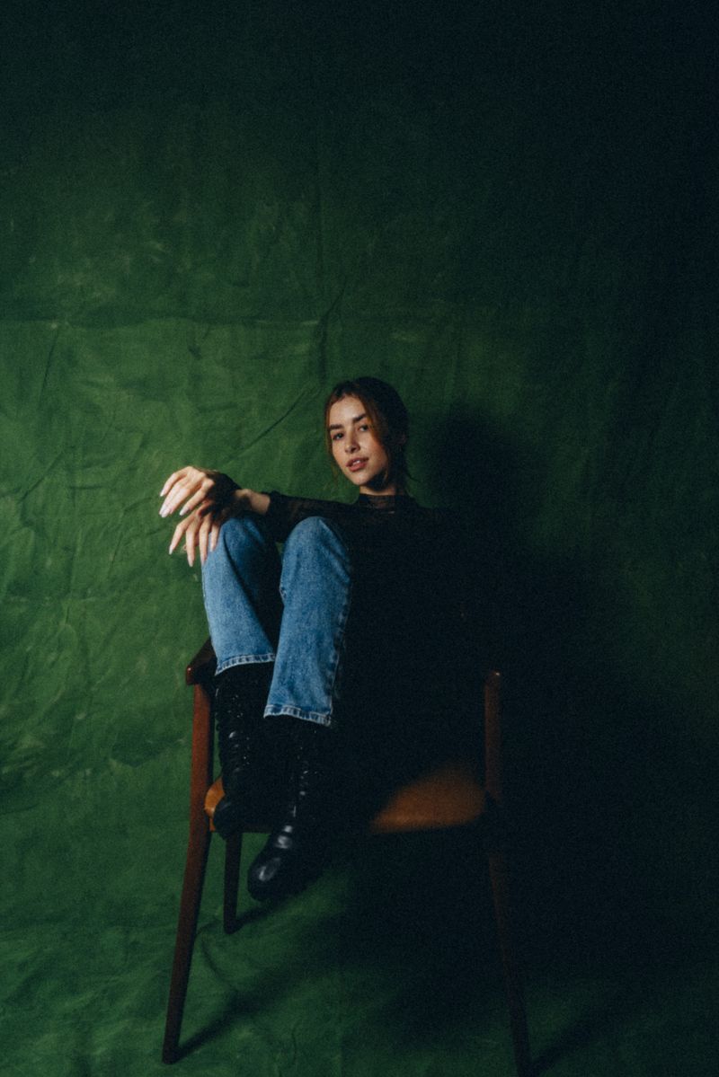 Seated figure in a low-lit studio, still from the festival title sequence &mdash; photo by Igor La Prado on Pexels
