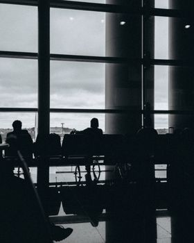 Silhouetted travelers wait at an airport terminal in Maringá, Brazil.