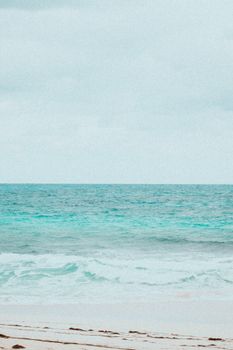 Peaceful beach scene with calm ocean waves and clear sky, perfect for relaxation.