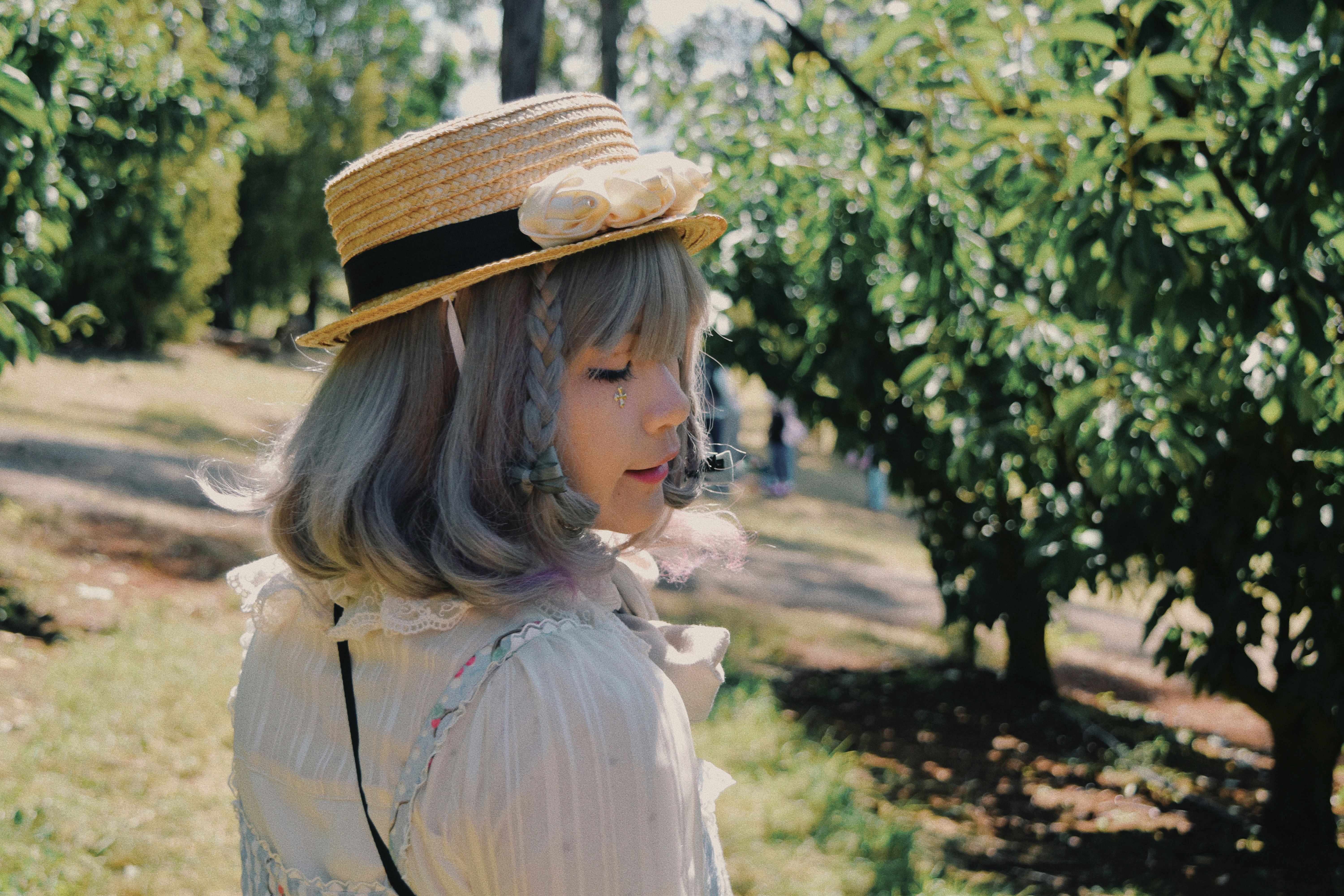 Charming Woman in Straw Hat Walking in Sunny Orchard · Free Stock Photo