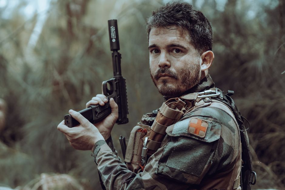 A SEAL platoon in jungle camouflage gear moving through dense brush A SEAL platoon in jungle camouflage gear moving through dense brush