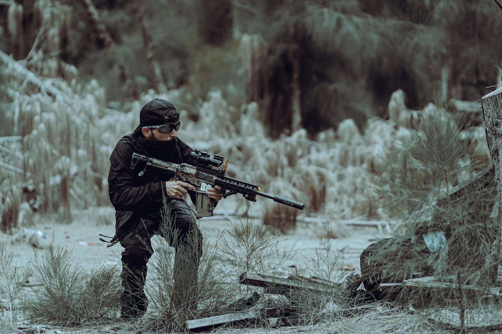 Man in tactical gear practicing outdoor training in Miami's wild forested area, focused and prepared.