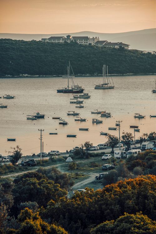 Free A tranquil bay scene with anchored boats and soft sunset light. Stock Photo