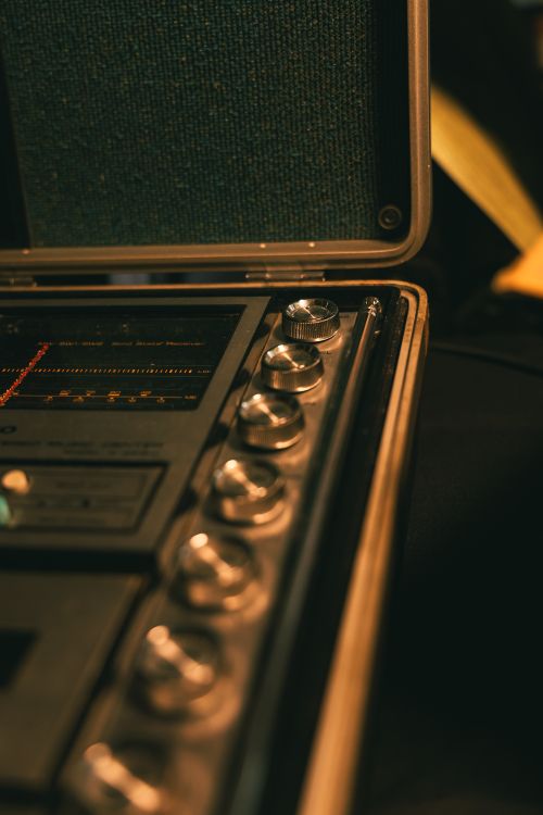 Free Close-up of vintage audio equipment with knobs and a radio frequency scale in low light. Stock Photo