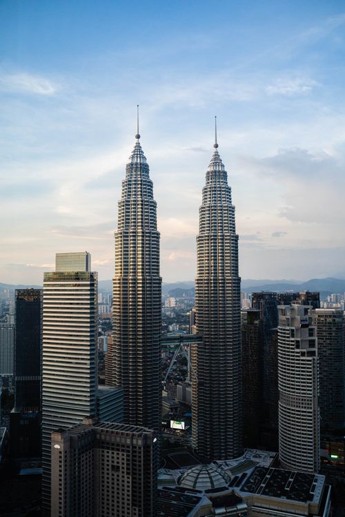 Free A stunning view of the iconic Petronas Towers dominating Kuala Lumpur's urban skyline at dawn. Stock Photo