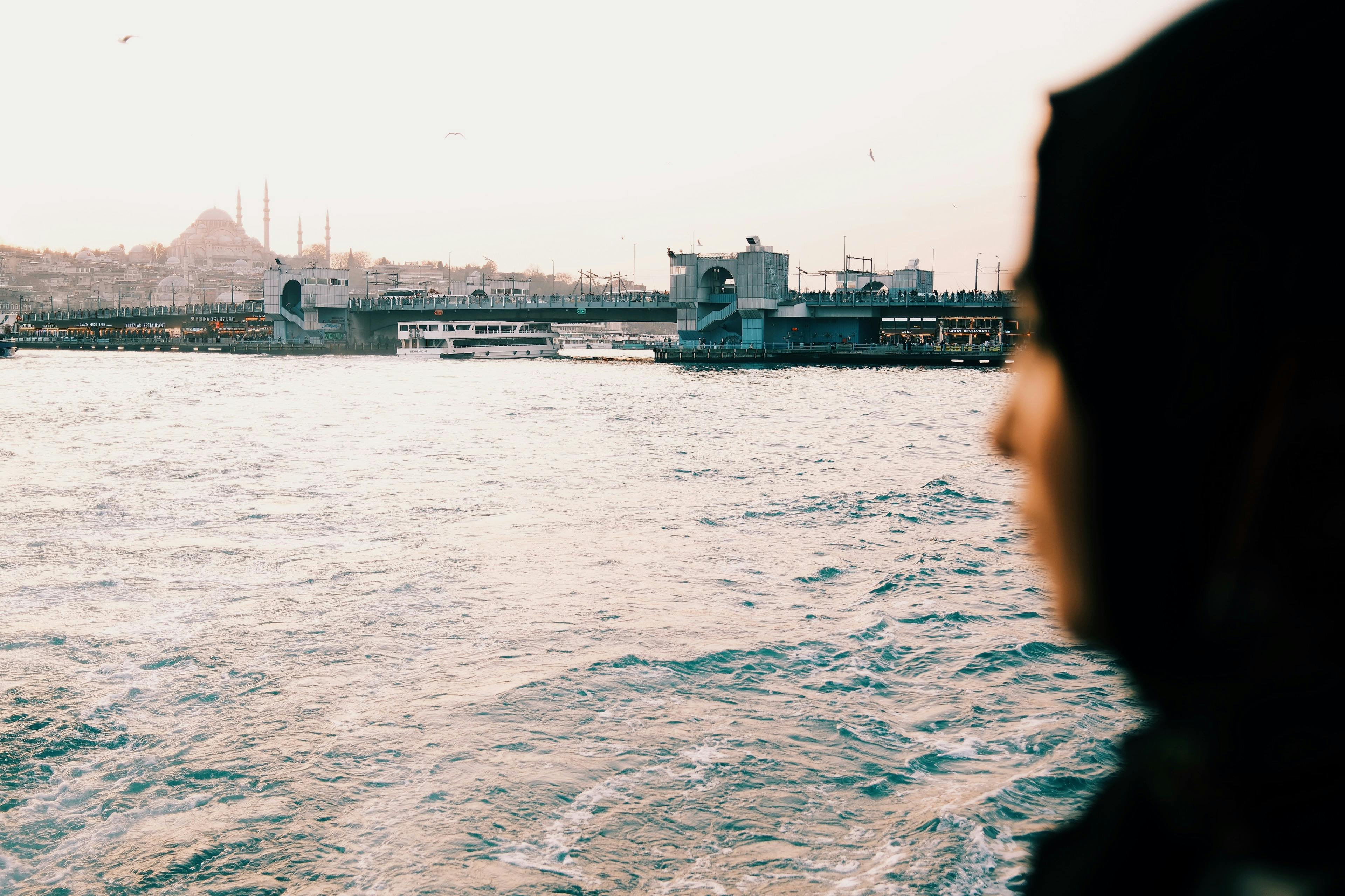 Gratuit Vue lointaine de l'horizon d'Istanbul avec une silhouette floue au premier plan, capturée au coucher du soleil. Photos