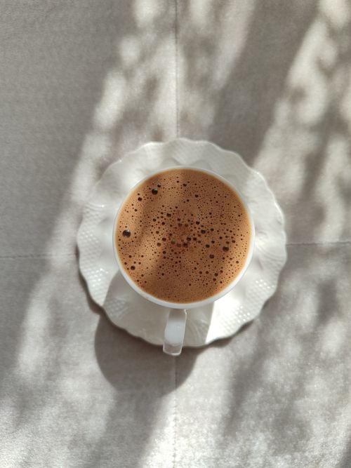 Free Artistic overhead shot of a coffee cup on a sunny day with soft shadows. Stock Photo