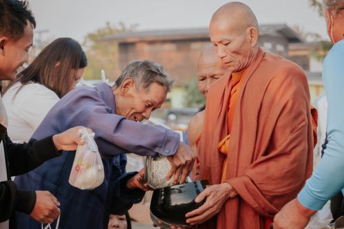 Free A group of Buddhist monks accepting offerings from villagers in a traditional ceremony. Stock Photo