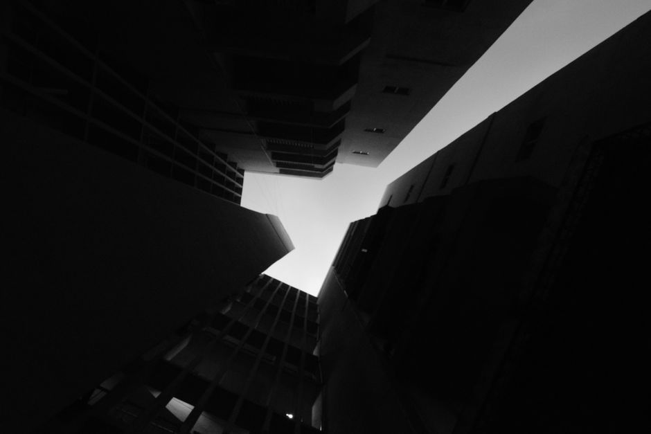 Stark contrast of towering building silhouettes forming a geometric pattern against the sky.