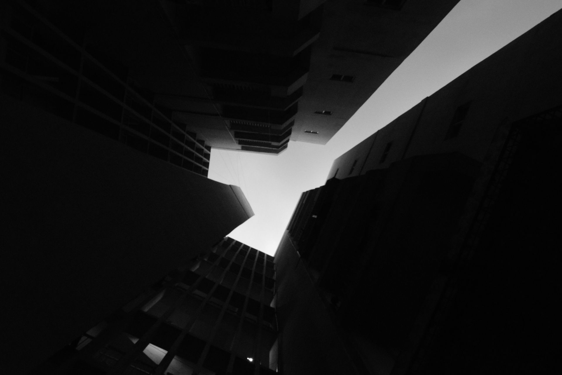 Stark contrast of towering building silhouettes forming a geometric pattern against the sky.
