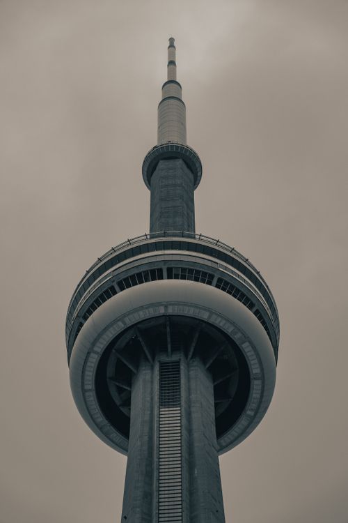 Free A striking low angle view of the CN Tower against a cloudy sky, capturing its architectural splendor. Stock Photo