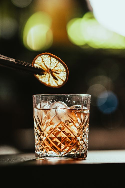 Free A refined cocktail served in a crystal glass with a citrus garnish, perfect for sophisticated gatherings. Stock Photo