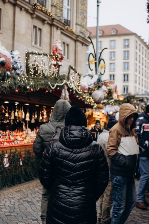 Free People enjoying a winter holiday market in Europe with festive decorations. Stock Photo