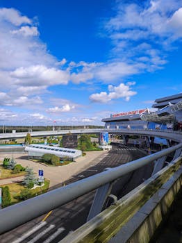 Modern airport terminal exterior with clear blue sky and vibrant signage.