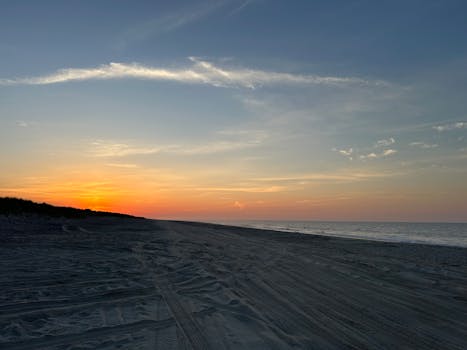 Peaceful beach scene at sunrise with a gentle morning glow over an empty shoreline.