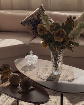 Cozy living room with elegant floral vase on sunlit coffee table.