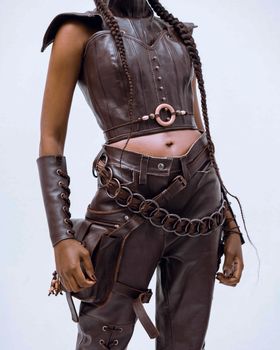 Stylish brown leather outfit with chains and intricate braids. Modern and edgy fashion.