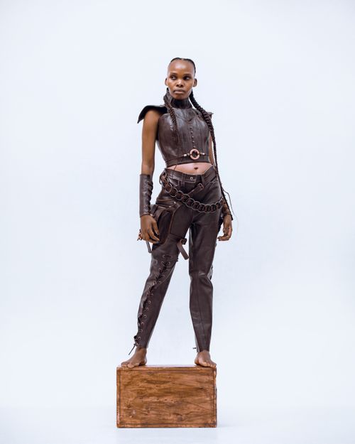 Free Young model showcasing a high-fashion leather ensemble with bold design elements. Stock Photo