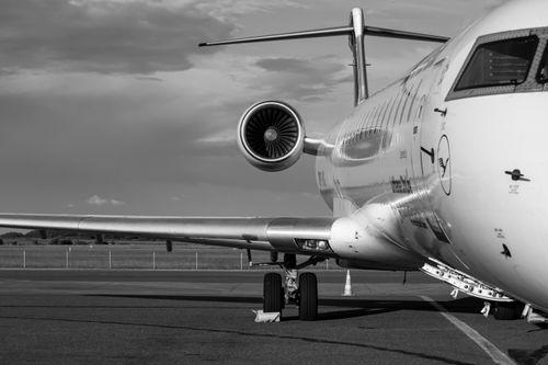 Free Monochrome photo of a commercial jet airplane taken from the side at an airport. Stock Photo