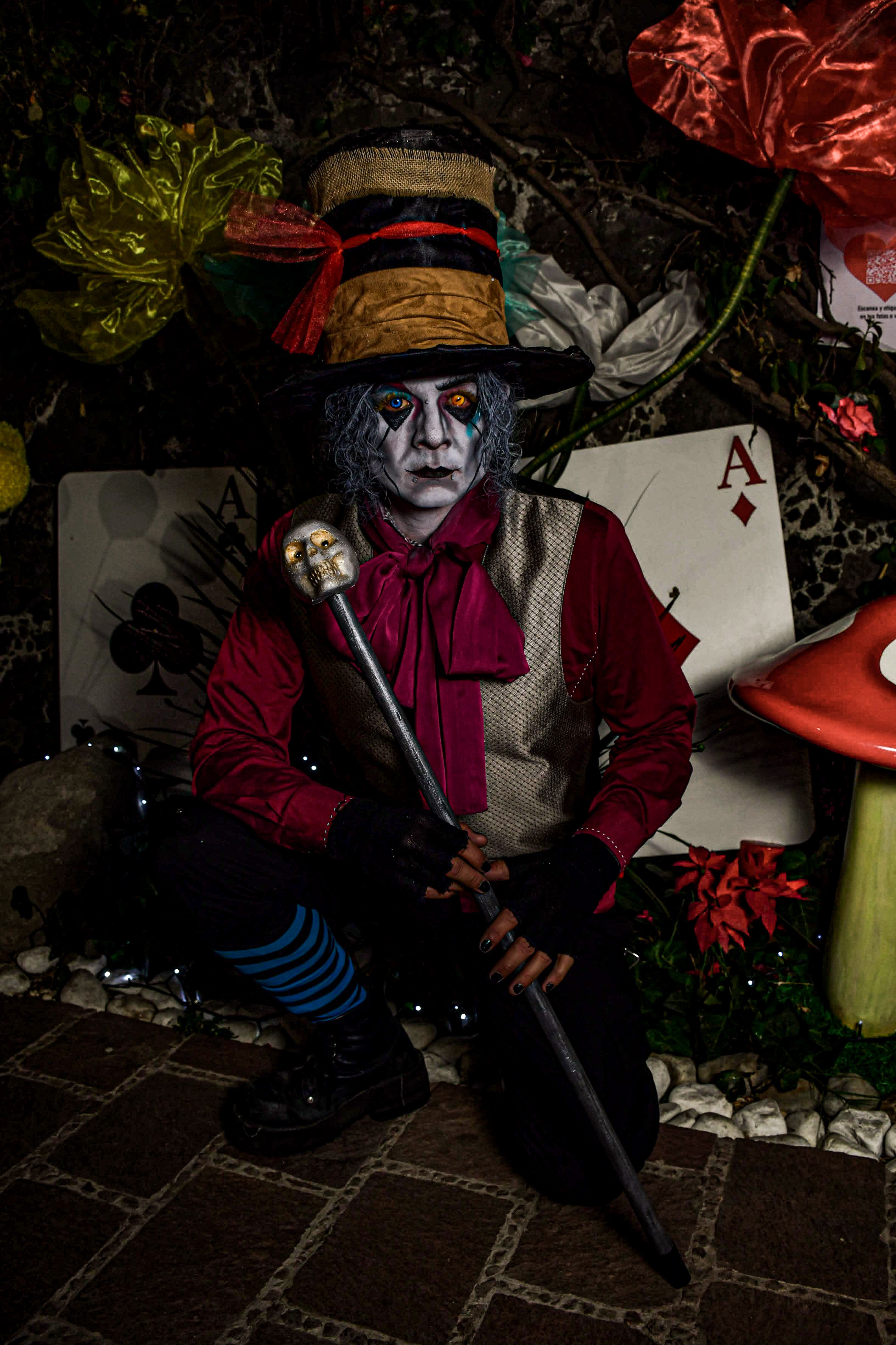A detailed cosplay of Mad Hatter from Alice in Wonderland, featuring a colorful costume and make-up.