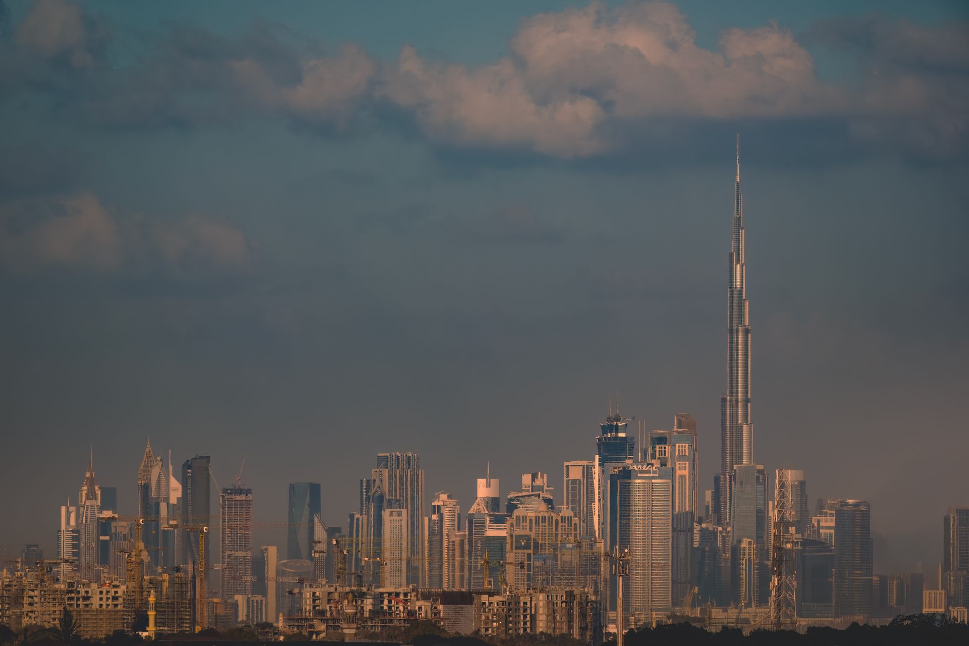Stunning view of Dubai skyline featuring the famous Burj Khalifa at dusk under a cloudy sky.