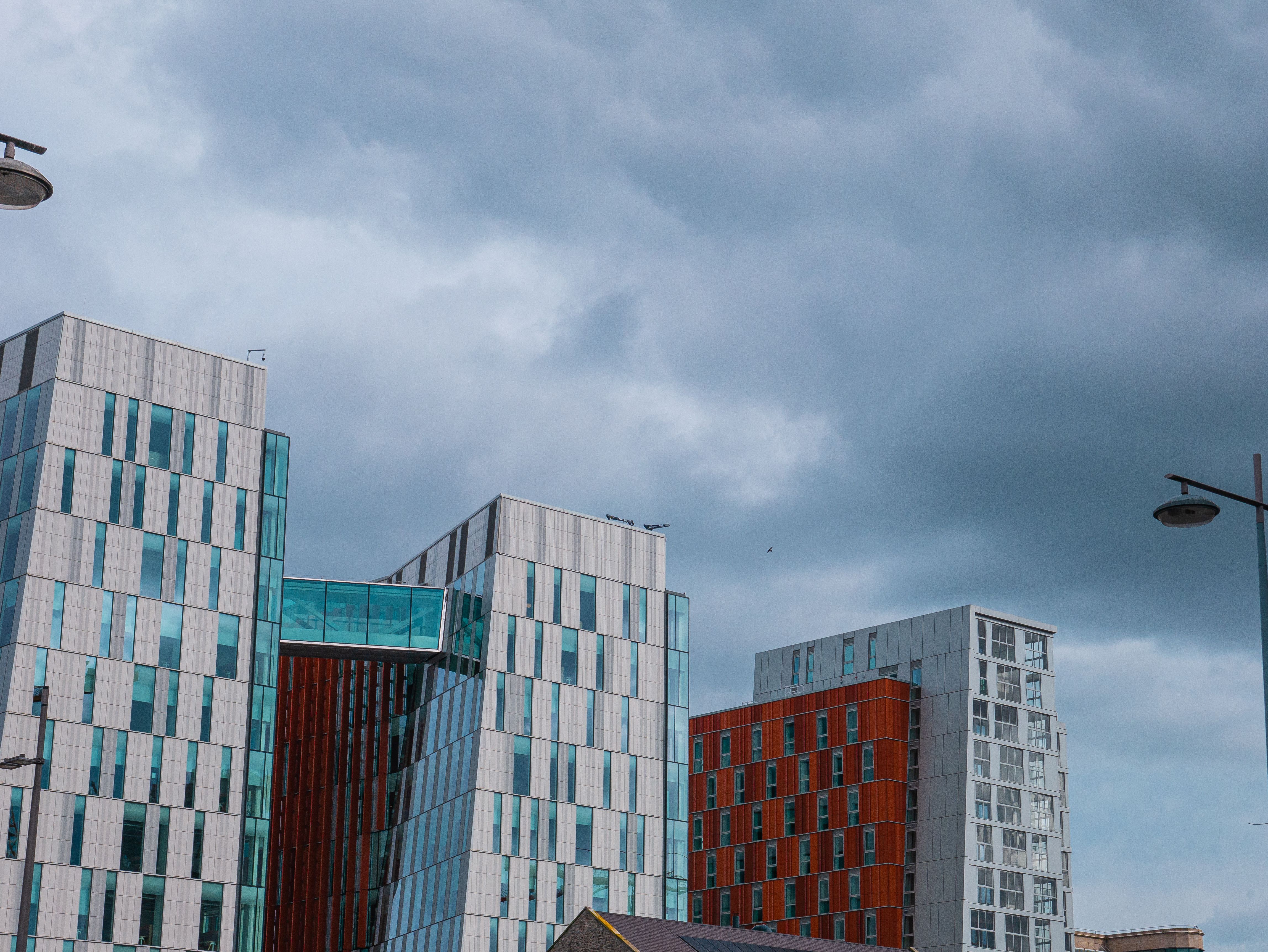Contemporary buildings in Dublin against a dramatic cloudy sky, showing modern architecture.