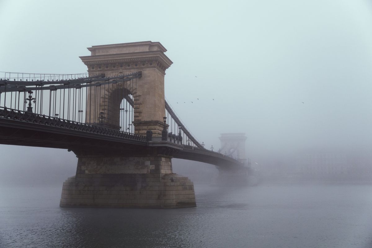 Pod cu lanturi si pilon in forma de arc de triumf, in ceata deasa