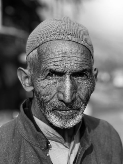 Free Detailed black and white portrait of an elderly man outdoors. Stock Photo